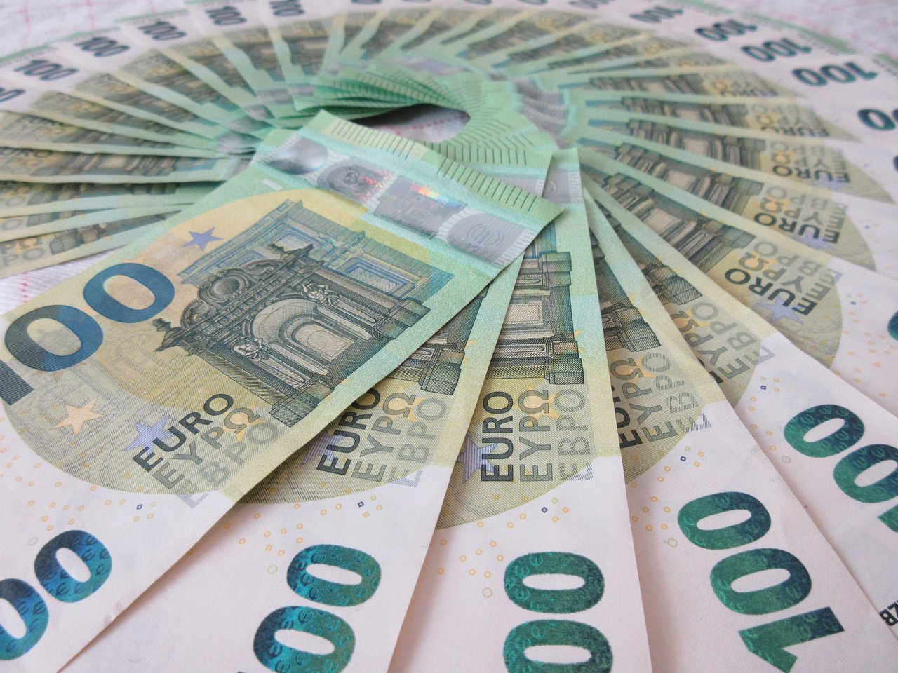 Close-up of fan spread 100 Euro banknotes, showcasing wealth and finance theme.